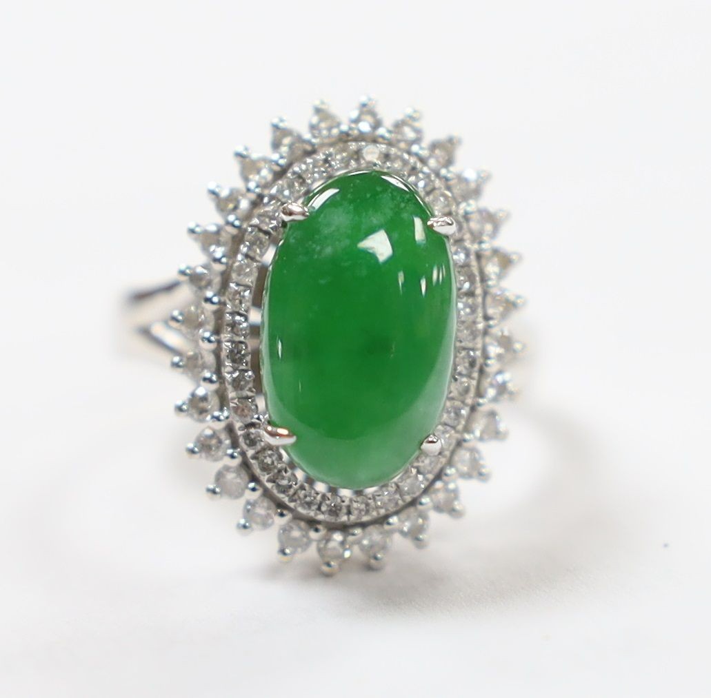 A modern 18k white metal, cabochon jade and two row diamond chip set oval cluster ring size L, gross weight 6.4 grams.